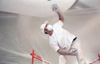 Worker sanding down new drywall